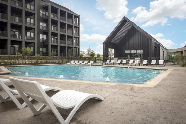 Outdoor pool with lounge area at Adaline at the Station Apartments