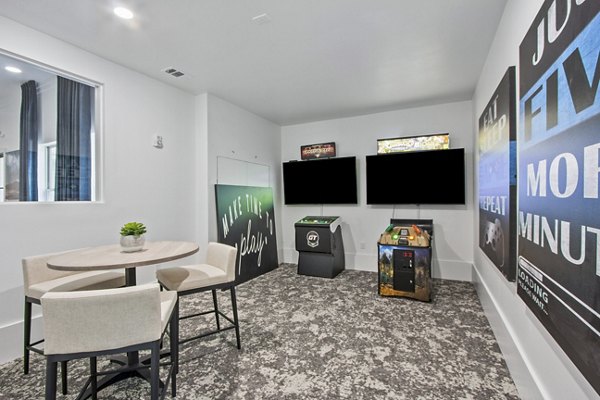 Game room with billiards and arcade games at Adara at Godley Station Apartments offering entertainment and fun for residents