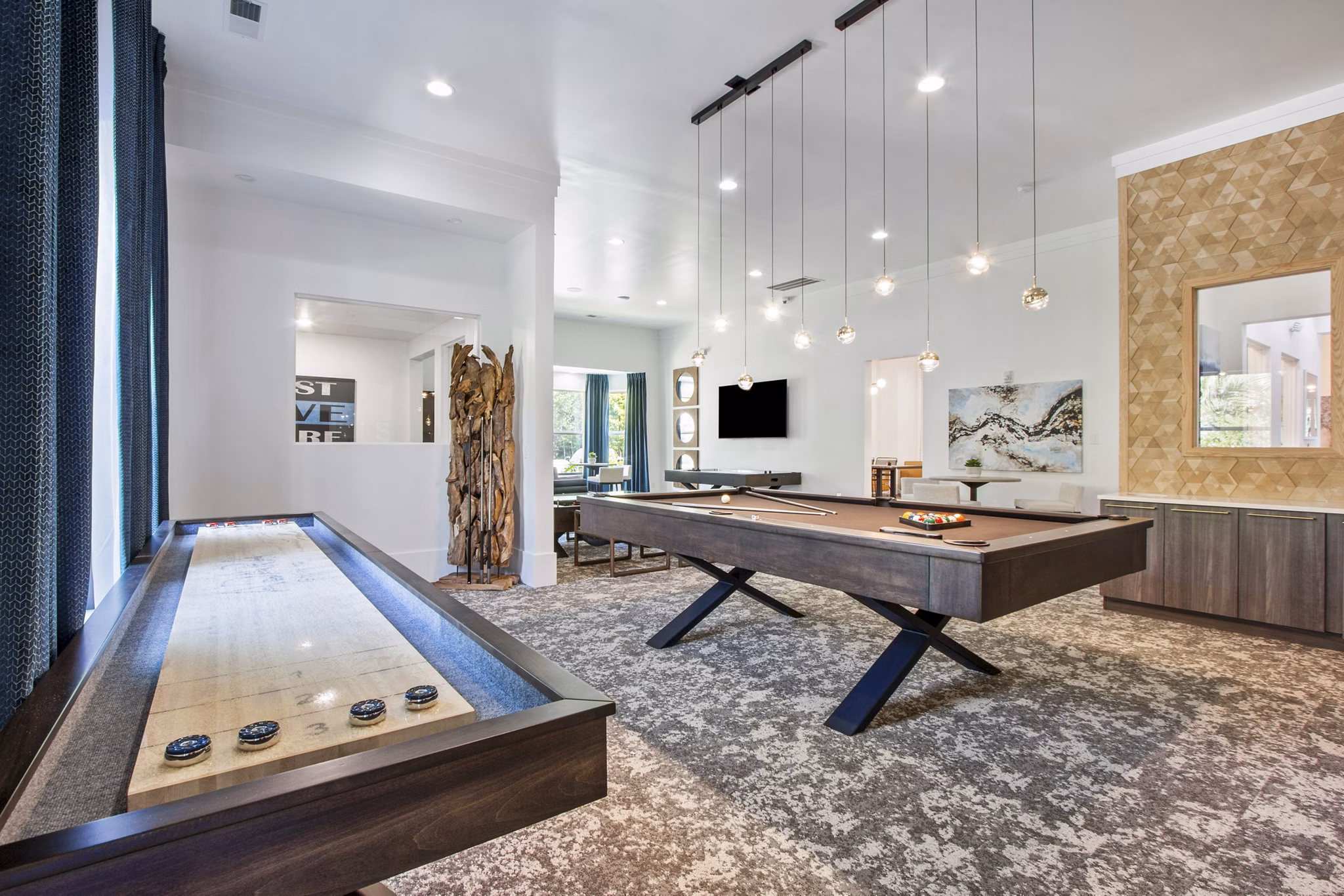 Modern game room with pool table and lounge chairs at Adara at Godley Station Apartments