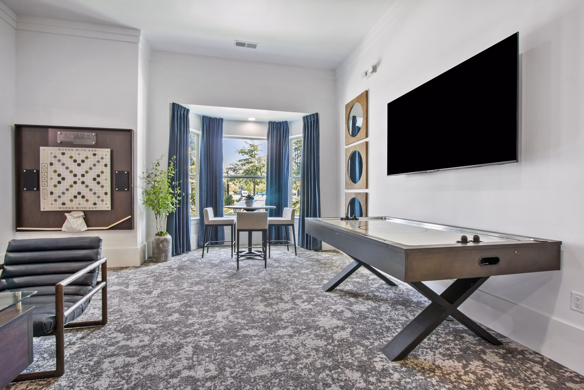 Game room with pool table and arcade games at Adara at Godley Station Apartments, offering fun recreational amenities for residents
