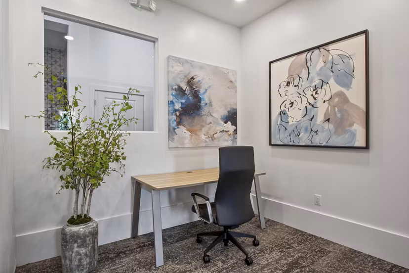 Home office featuring ergonomic desk and large window in Adara at Godley Station Apartments