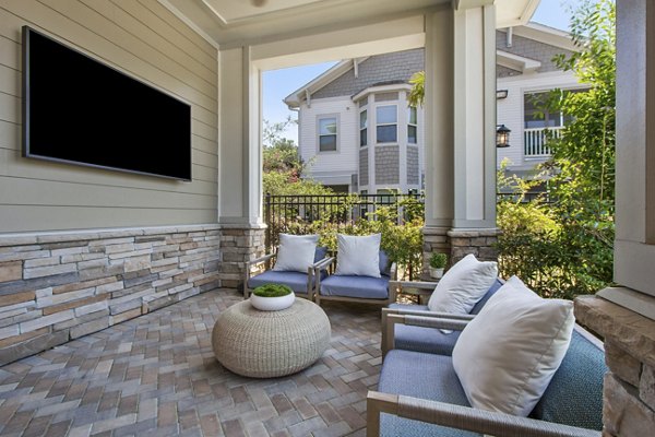 Charming outdoor patio with lush landscaping at Adara at Godley Station Apartments, ideal for relaxation and socializing