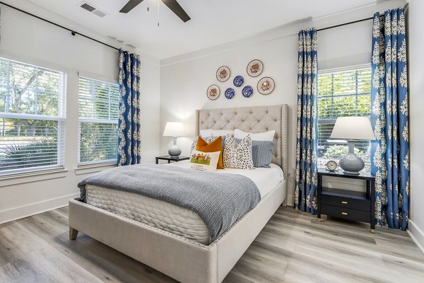 Cozy bedroom with modern decor at The Avenues at Verdier Pointe Apartments, showcasing luxury living spaces by Greystar