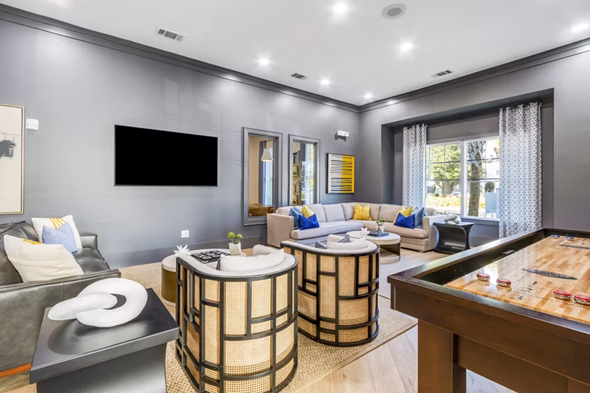 Clubhouse game room with pool table and lounge seating at The Avenues at Verdier Pointe Apartments