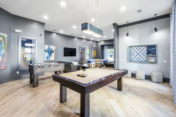 Clubhouse game room with billiards and seating in The Avenues at Verdier Pointe Apartments