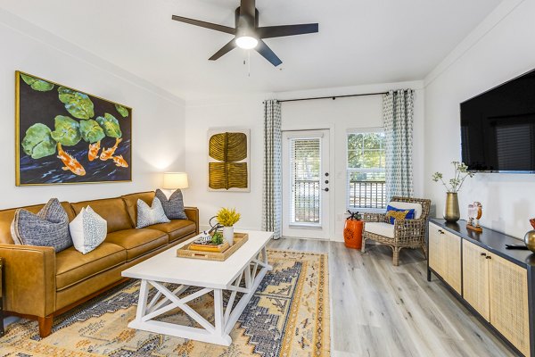 Contemporary living room with plush seating and natural light at The Avenues at Verdier Pointe Apartments