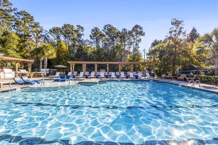 Resort-style pool at The Avenues at Verdier Pointe Apartments featuring sundeck and lounge chairs, offering luxury relaxation