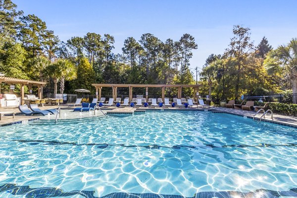 Resort-style pool at The Avenues at Verdier Pointe Apartments featuring sundeck and lounge chairs, offering luxury relaxation