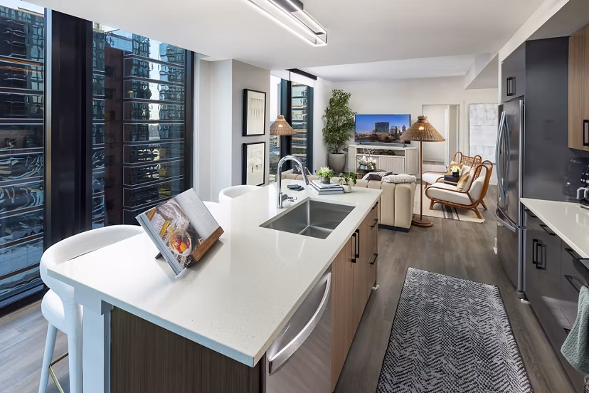 Modern kitchen with stainless steel appliances at Nomia Apartments, featuring sleek countertops and ample cabinet space