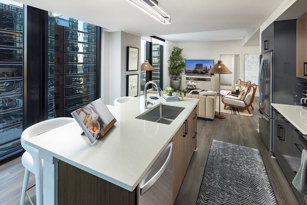 Modern kitchen with stainless steel appliances at Nomia Apartments, featuring sleek countertops and ample cabinet space
