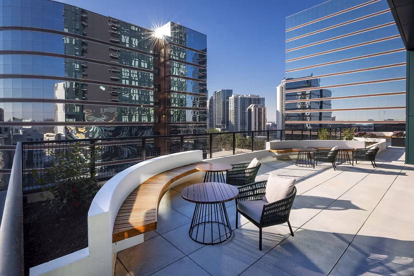 Rooftop deck with modern seating and city views at Nomia Apartments, perfect for relaxation and gatherings