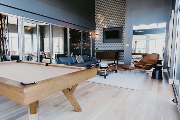 Modern game room with pool table and lounge seating at Tanager Apartments, luxury residential community