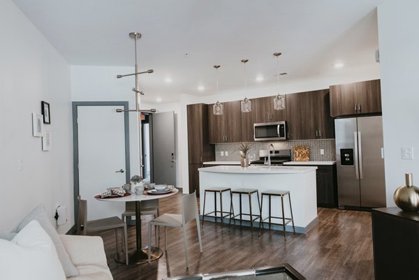 Bright living room with modern furnishings and large windows at Tanager Apartments