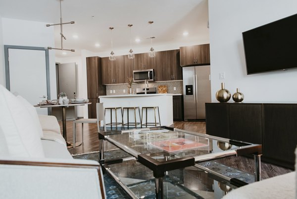 Sunny living room with elegant furnishings and large windows at Tanager Apartments