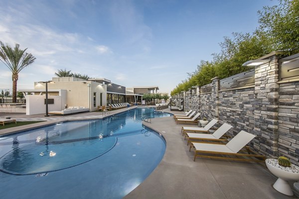 Luxurious pool at Tanager Apartments with lounge chairs and greenery, offering a premium leisure experience for residents