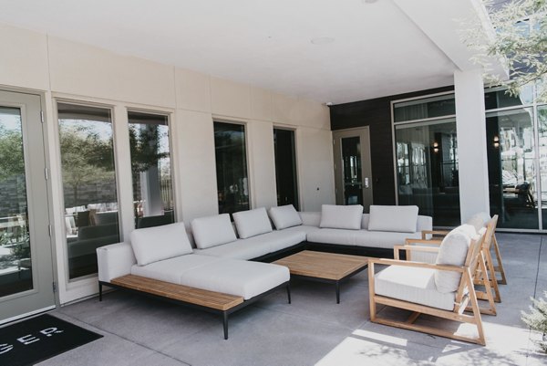 Stylish outdoor patio with comfy seating at Tanager Apartments perfect for relaxing, surrounded by lush landscaping