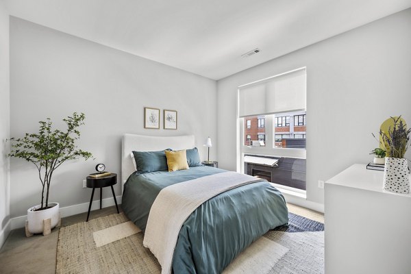 Modern bedroom with elegant decor and ample natural light at Arris Apartments