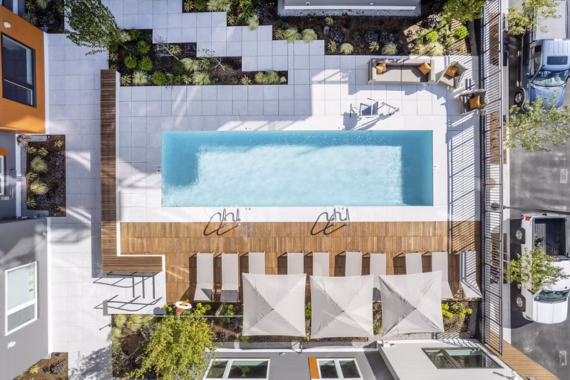 Modern outdoor pool with lounge chairs at Arris Apartments, ideal for relaxation and leisure in a luxury setting