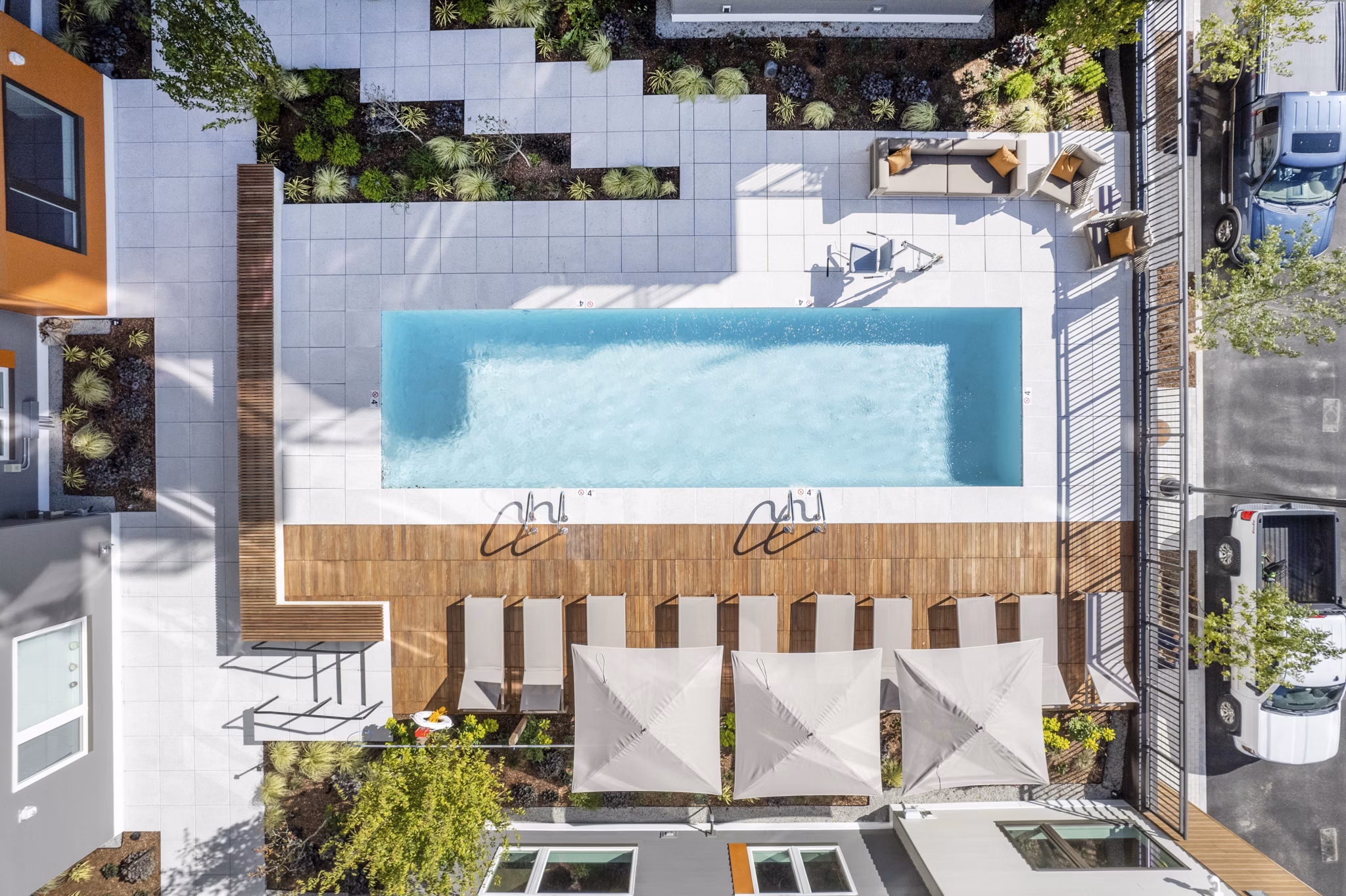 Modern outdoor pool with lounge chairs at Arris Apartments, ideal for relaxation and leisure in a luxury setting