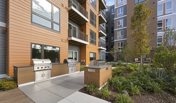 Outdoor grill area with modern seating at Arris Apartments, perfect for gatherings and relaxation in a luxury community setting