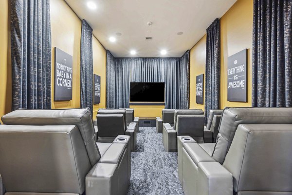 Clubhouse theater with plush seating and large screen at Hideaway North Scottsdale Apartments