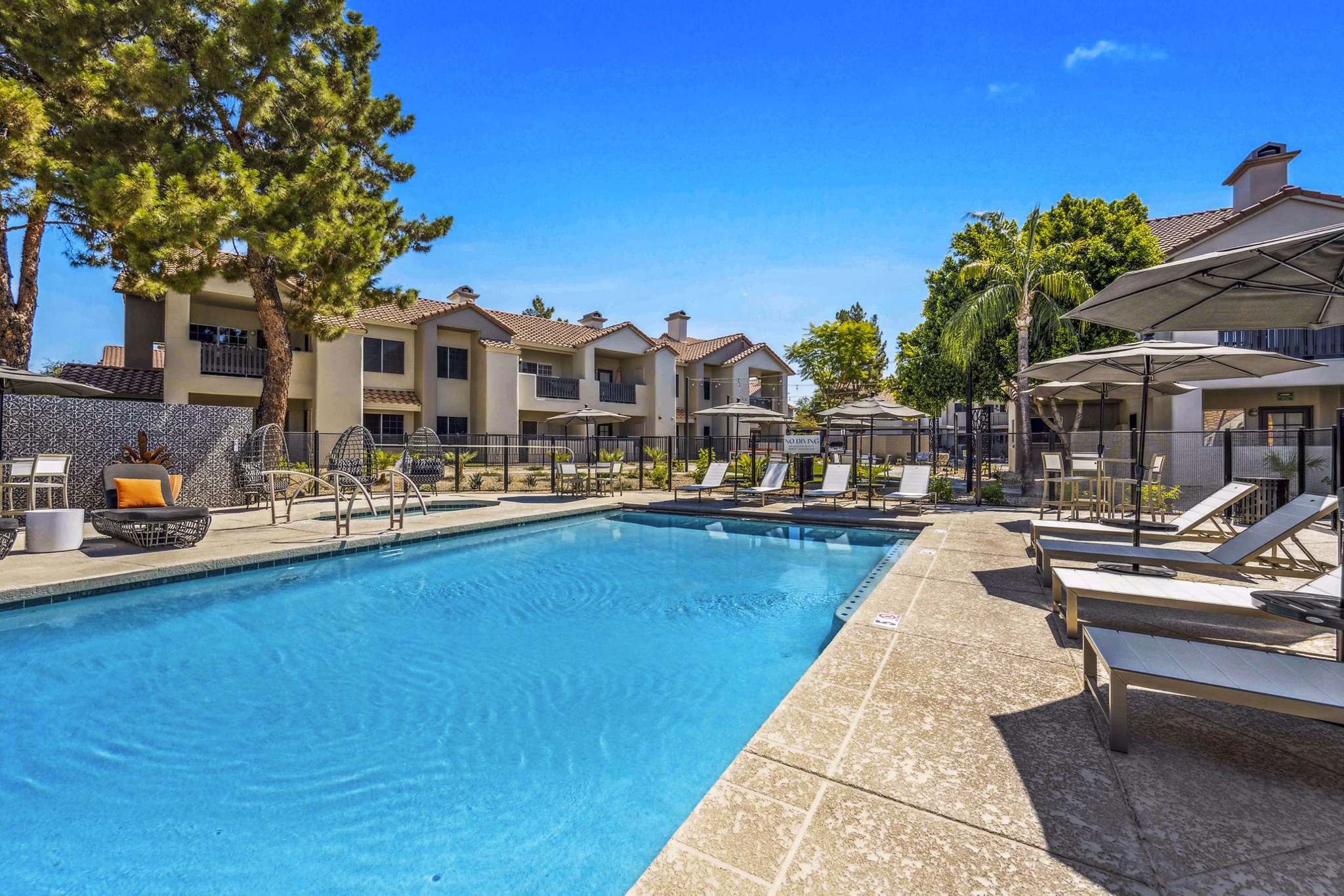 Relaxing pool area with lounge chairs at Hideaway North Scottsdale Apartments, perfect for leisurely sunbathing and swimming in Arizona's tranquil setting