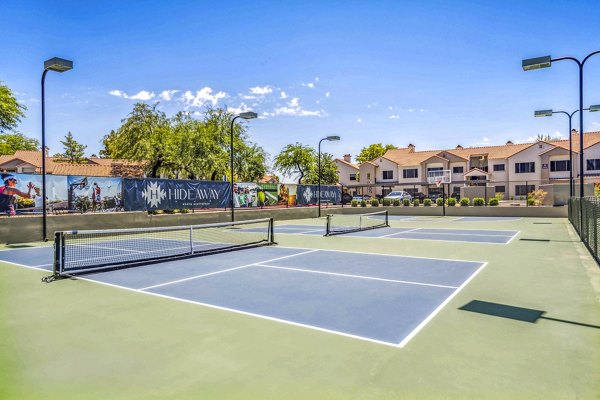 Tennis courts at Hideaway North Scottsdale Apartments featuring well-maintained surfaces and lush surroundings
