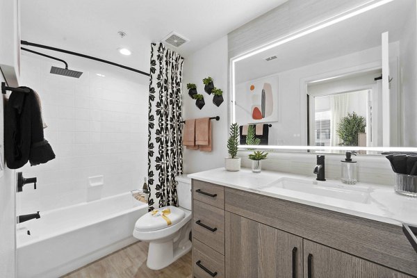 Luxurious bathroom featuring marble countertops and a glass shower at Nines at Kierland Apartments