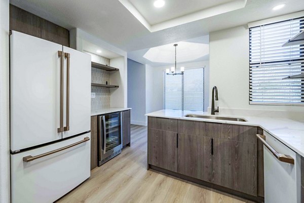 Modern kitchen with granite countertops and stainless steel appliances at Nines at Kierland Apartments