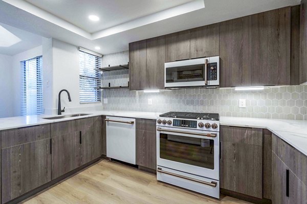 Modern kitchen with stainless steel appliances and granite countertops in Nines at Kierland Apartments