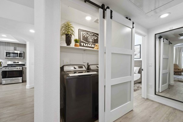 Laundry room with high-efficiency washers and dryers at Nines at Kierland Apartments