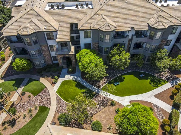 Aerial view of landscaped grounds with pathways and trees surrounding luxury apartments