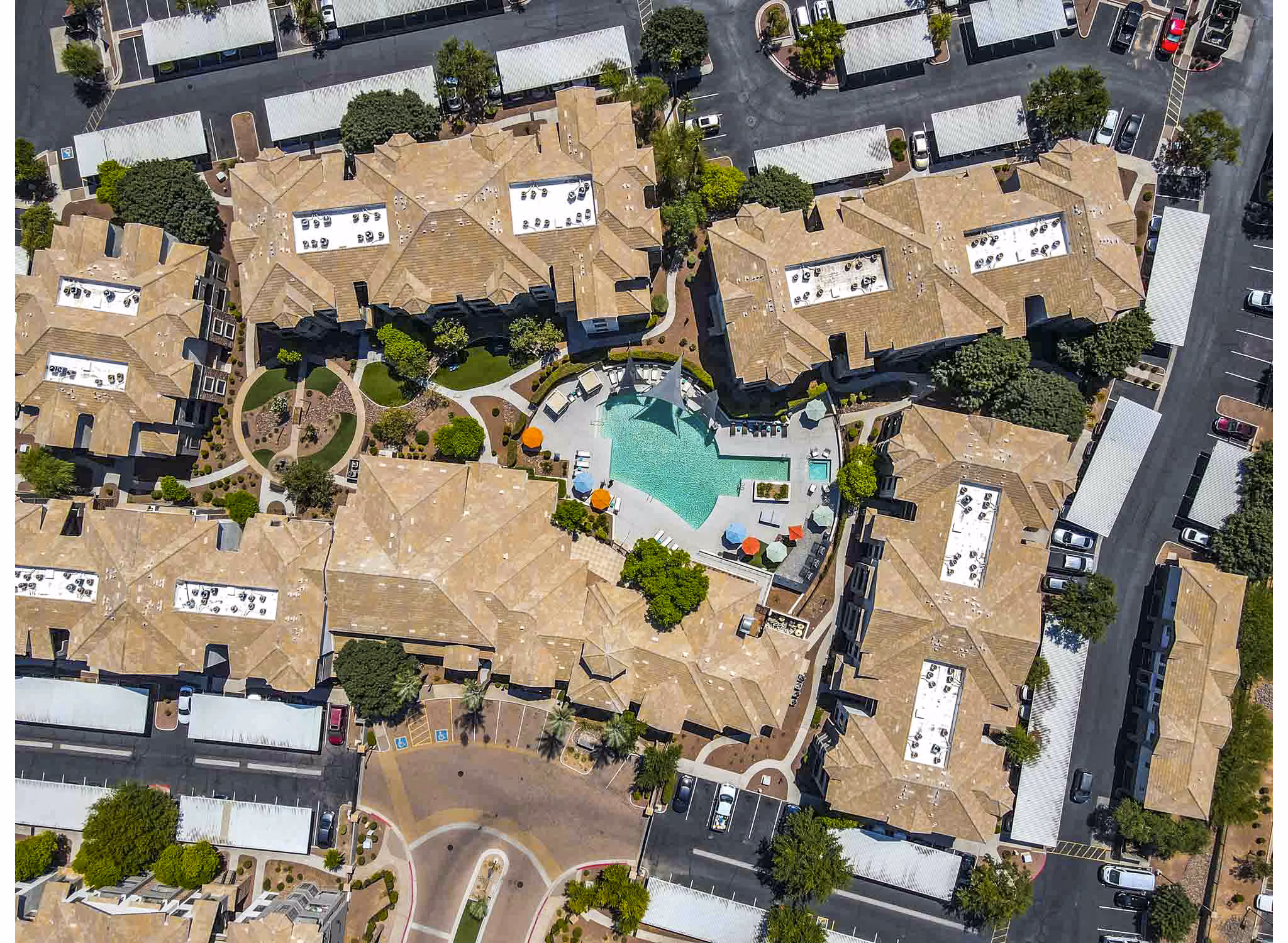 Aerial view of luxury apartments with a central swimming pool in a beautifully landscaped community