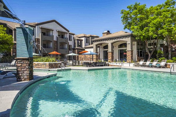 Resort-style pool at Zone Apartments with lounge chairs and lush landscaping, offering a luxury relaxation experience