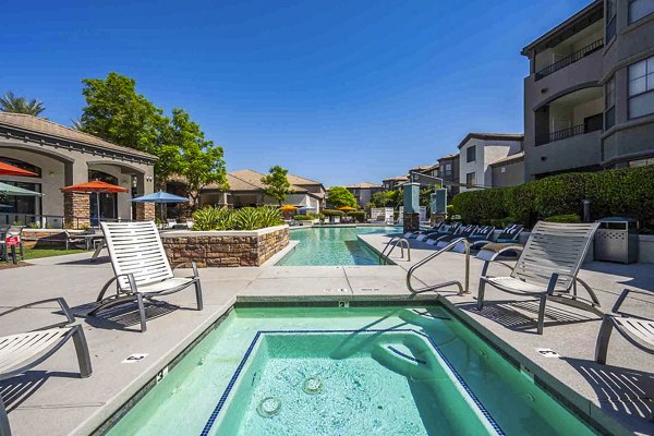 Relaxing outdoor pool with adjacent hot tub at Zone Apartments, offering a luxury retreat experience