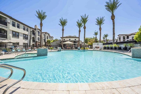 Luxurious swimming pool area at Zone Luxe Apartments with modern lounge chairs and surrounding greenery, offering a premium leisure experience