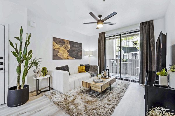 Living room with modern decor at Zone Westgate Apartments, featuring stylish seating and natural light in luxury Greystar apartments