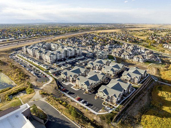 Picturesque view at Five810 Southlands Apartments: Modern architecture set against lush greenery in Aurora, CO
