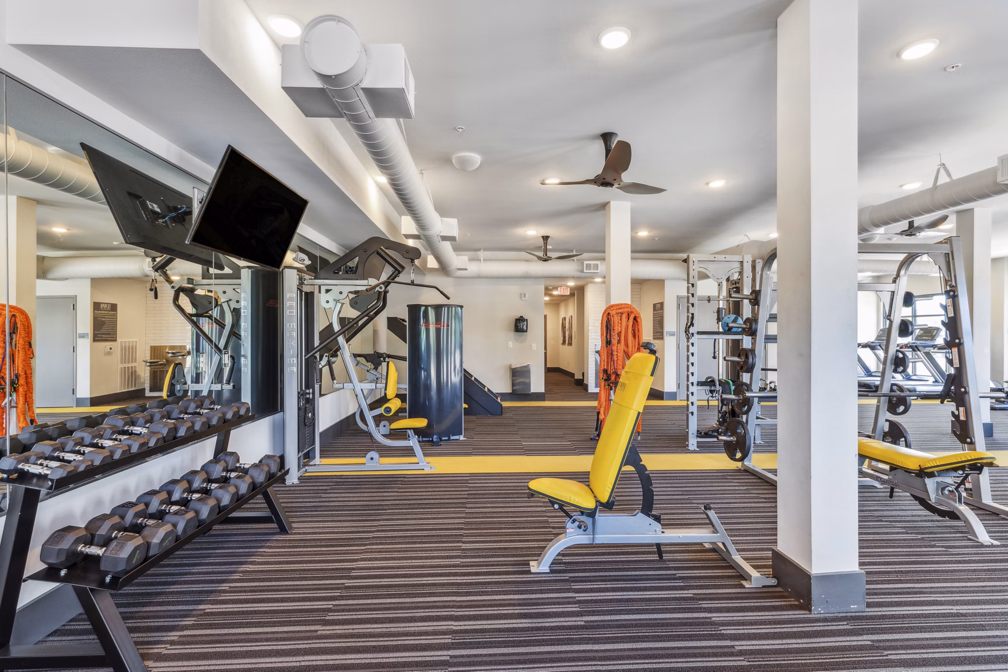 State-of-the-art fitness center at Mezz at Fiddler's Green Apartments with modern equipment and spacious workout areas