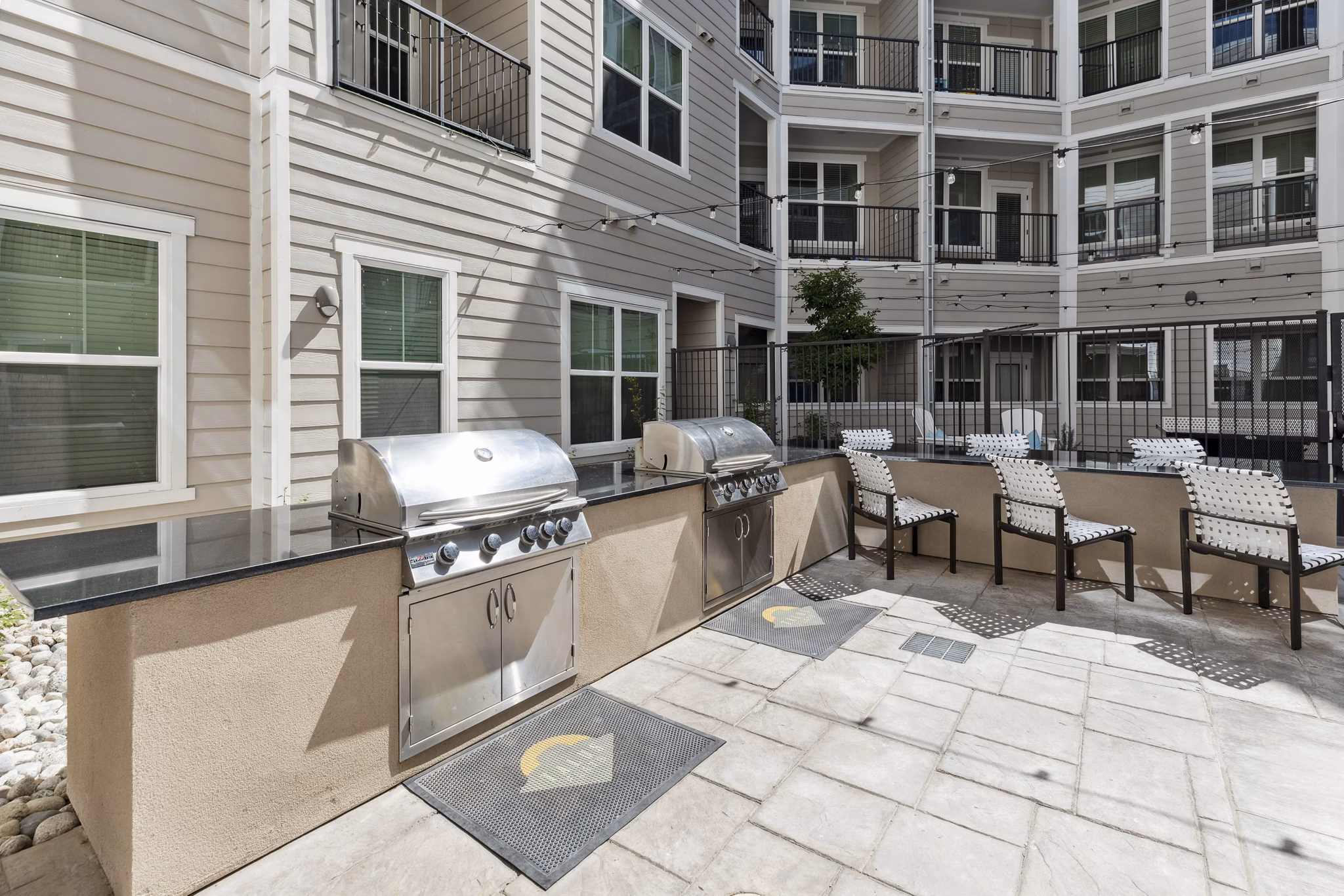 â€œOutdoor grill area with seating at Talus Flats Apartments, offering residents a modern space for socializing and cooking in styleâ€