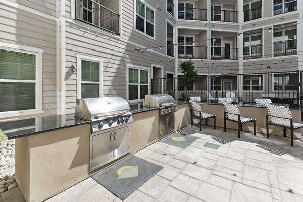 â€œOutdoor grill area with seating at Talus Flats Apartments, offering residents a modern space for socializing and cooking in styleâ€