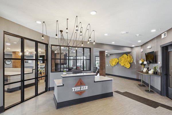 The Zeb Apartments: Chic clubhouse featuring modern decor and ample seating in luxury community