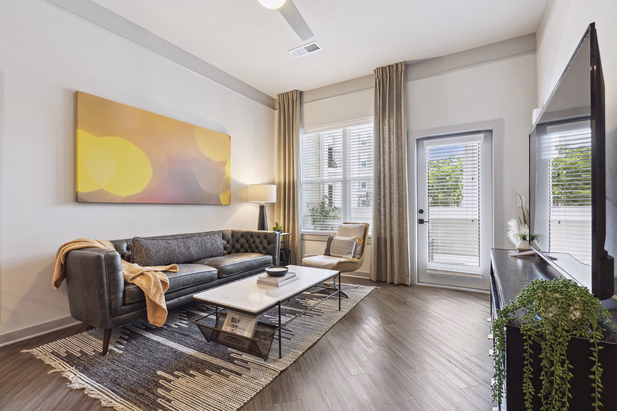 Spacious living room with contemporary decor and large windows at The Zeb Apartments