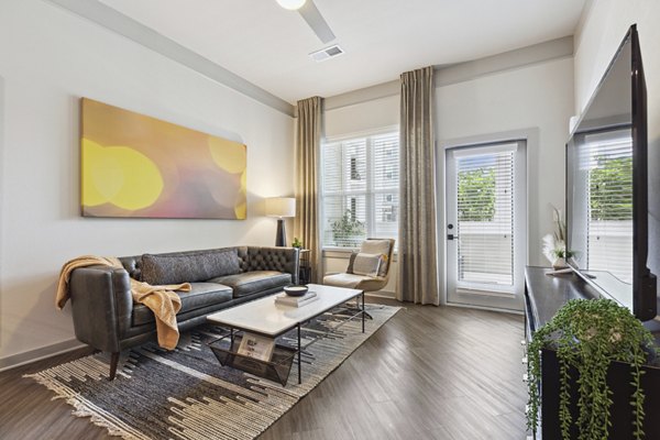 Spacious living room with contemporary decor and large windows at The Zeb Apartments