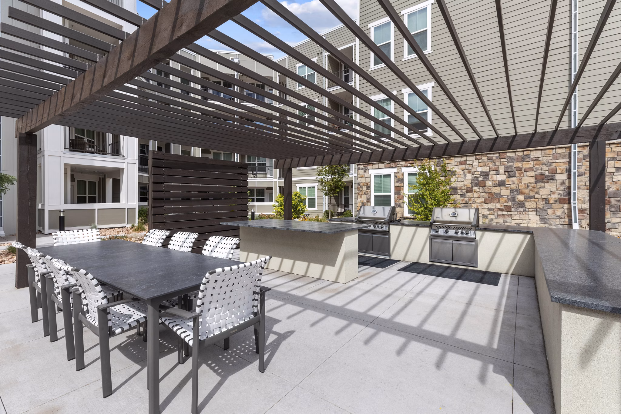 Grill area with modern outdoor seating at The Zeb Apartments, perfect for hosting gatherings in a luxury urban setting