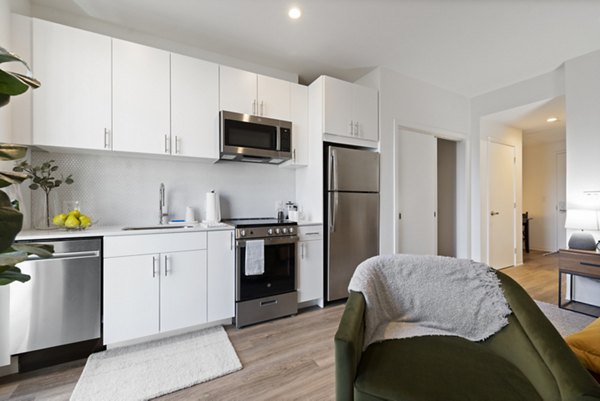 Modern kitchen featuring stainless steel appliances and quartz countertops at The Clark Apartments, luxury living by Greystar
