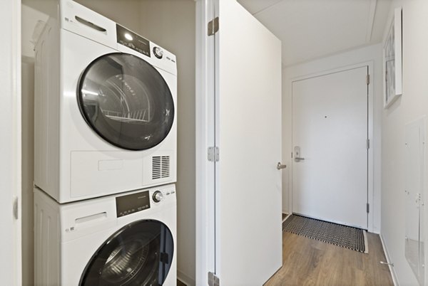 Laundromat featuring modern washers and dryers in The Clark Apartments, a Greystar luxury property