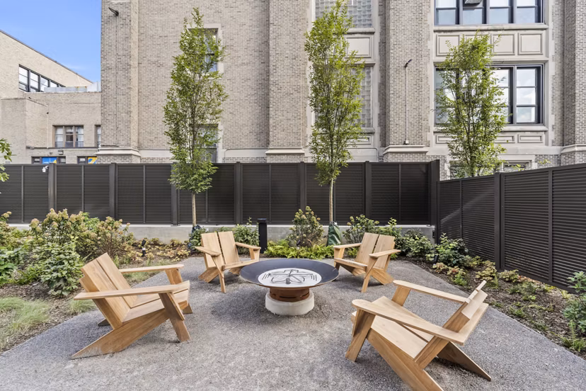 Cozy fire pit area at The Clark Apartments, perfect for social gatherings and relaxation in a luxurious setting