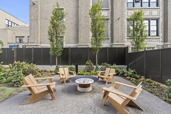 Cozy fire pit area at The Clark Apartments, perfect for social gatherings and relaxation in a luxurious setting