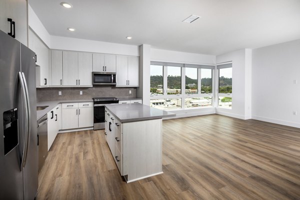 Modern kitchen with stainless steel appliances at Vora Lux Apartments